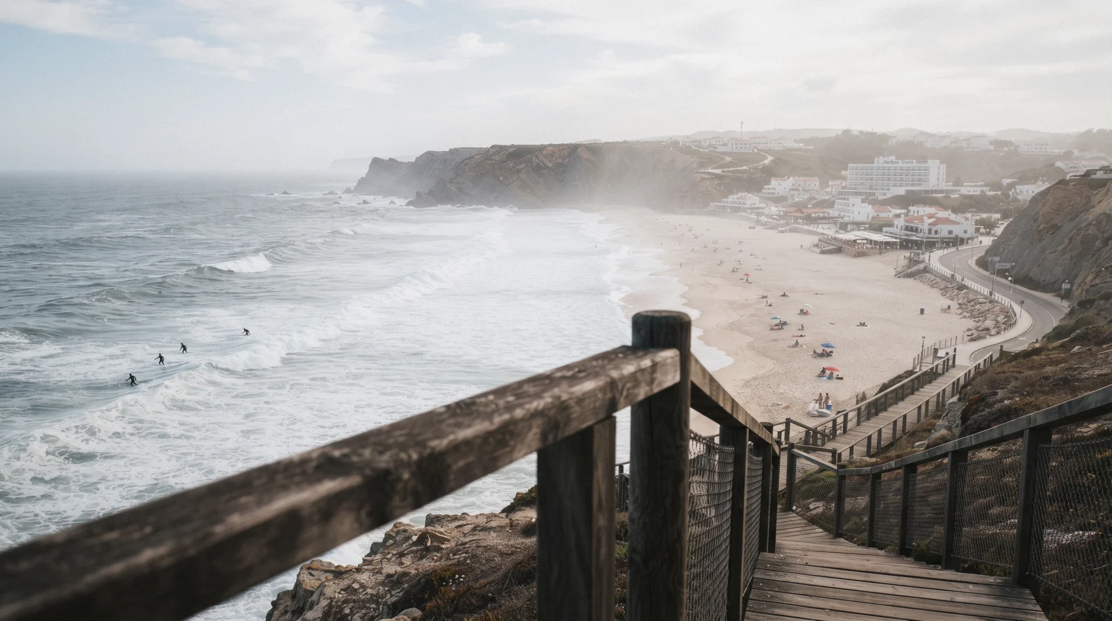 Surfers in the swell off the long white sand of Praia Grande on the Sintra coast, Portugal